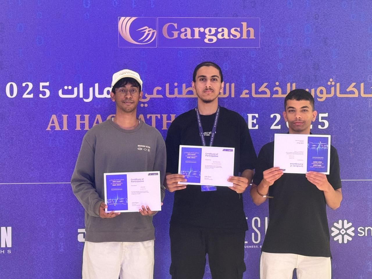 Three people holding certificates of participation in front of an AI Hackathon UAE 2025 backdrop.