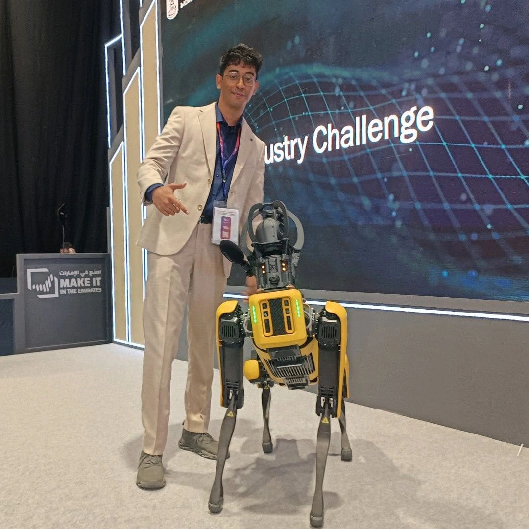 A Boston Dynamics Spot quadruped robot on the Industry Challenge floor, next to a Make it in the Emirates lectern.