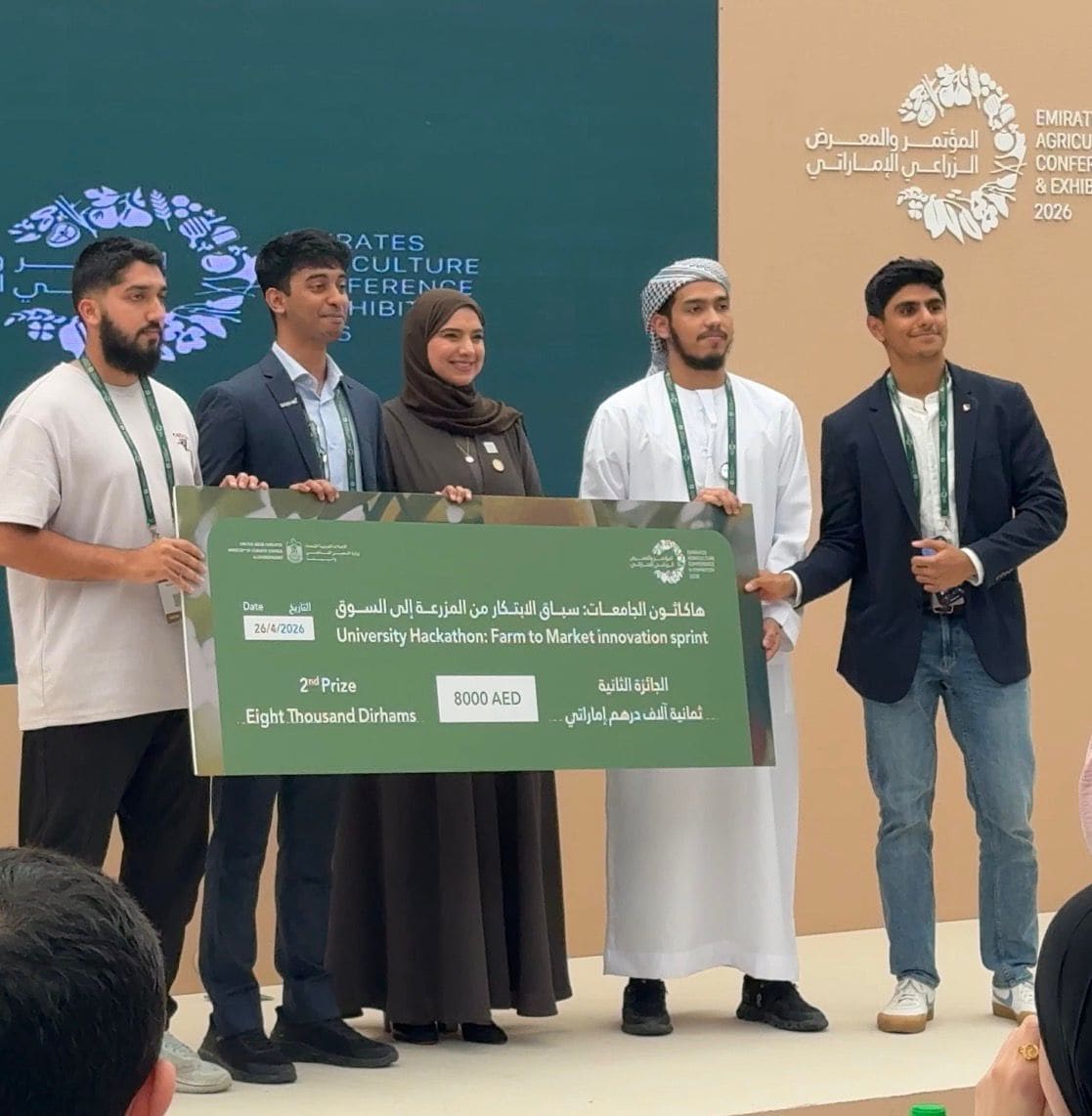 A prize board reading 'University Hackathon: Farm to Market innovation sprint - 2nd Prize, Eight Thousand Dirhams, 8000 AED', dated 26 April 2026, held on stage.