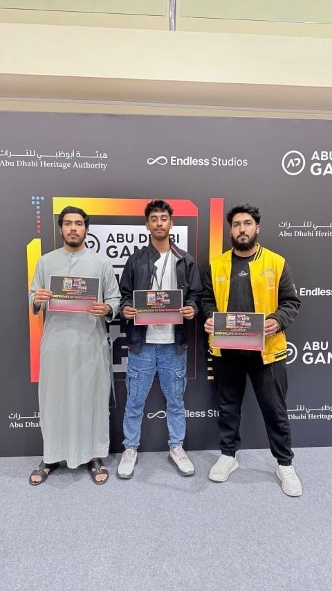 Three people holding certificates of participation in front of a SHIFT Game Jam backdrop carrying the Abu Dhabi Gaming, Abu Dhabi Heritage Authority and Endless Studios logos.