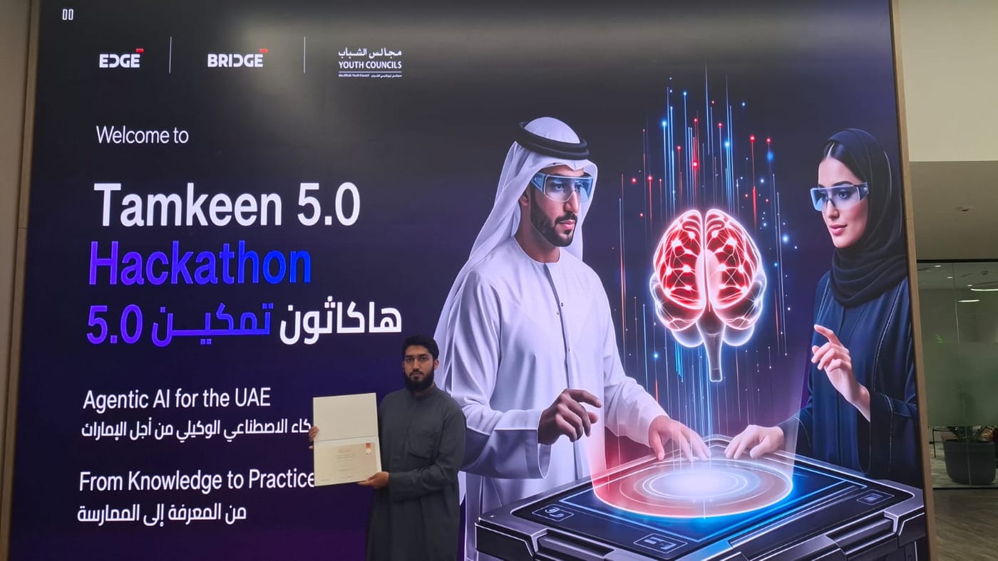 A welcome board reading 'Welcome to Tamkeen 5.0 Hackathon - Agentic AI for the UAE - From Knowledge to Practice', with EDGE, BRIDGE and Youth Councils logos, and a person standing in front of it holding a certificate.